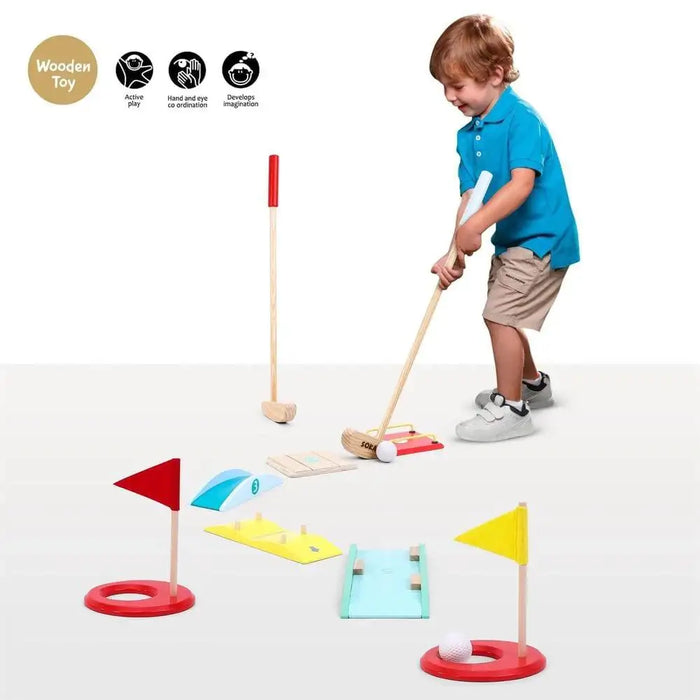 Child playing with wooden kids golf set indoors, colorful mini-golf obstacles and flags