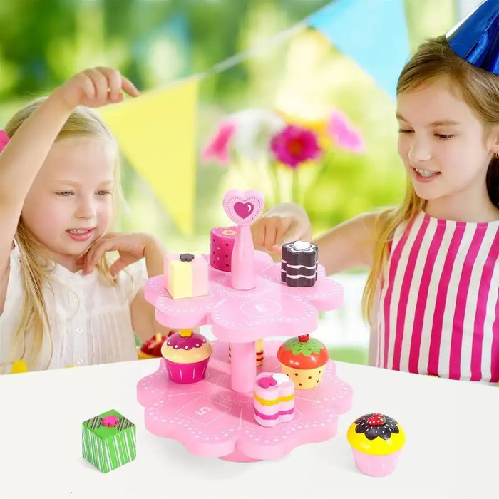 Children playing with a pink wooden magnetic cake stand pretend tea set and desserts