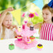 Children playing with a pink wooden magnetic cake stand pretend tea set and desserts