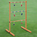 Wooden ladder toss game with red and blue bolas on green grass