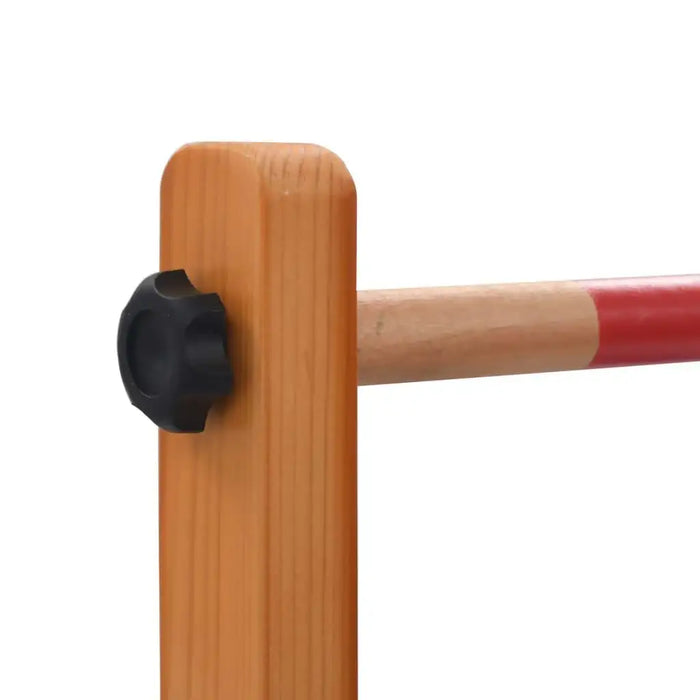 Close-up of wooden spin ladder game frame and red bar with black knob